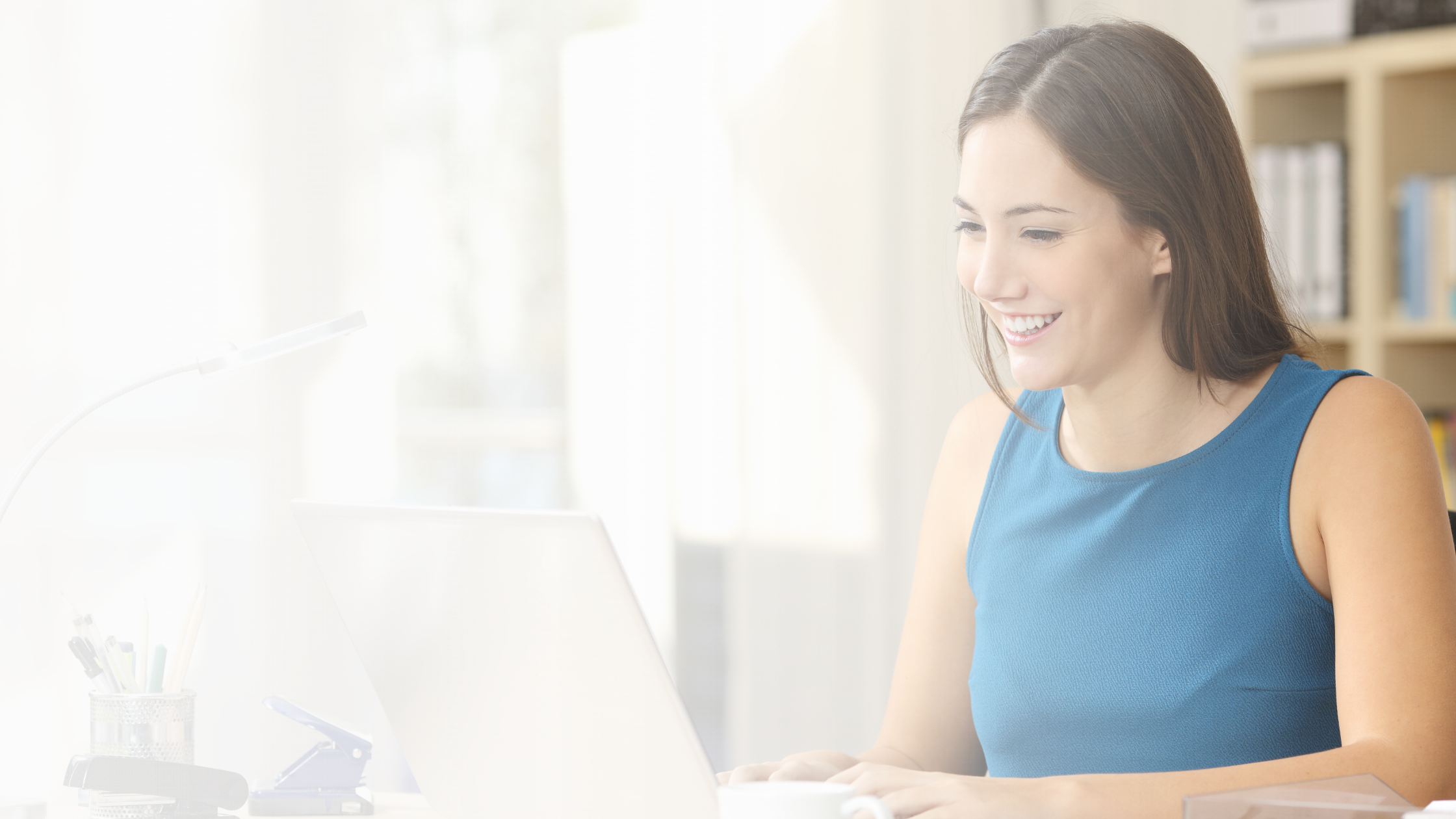 young woman smiling at laptop - white transparency